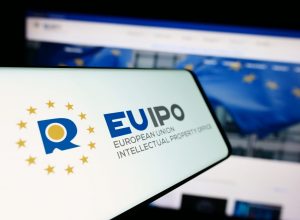 Stuttgart, Germany - 10-17-2023: Mobile phone with logo of European Union Intellectual Property Office (EUIPO) in front of website. Focus on center-left of phone display.